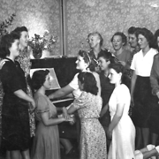 Women gathered around a piano at Tower House Young Women's Hostel